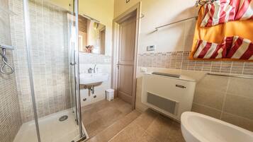 A bathroom with a glass shower enclosure, a sink, a toilet, and a bathtub.