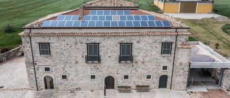 A stone building with a tiled roof and solar panels.