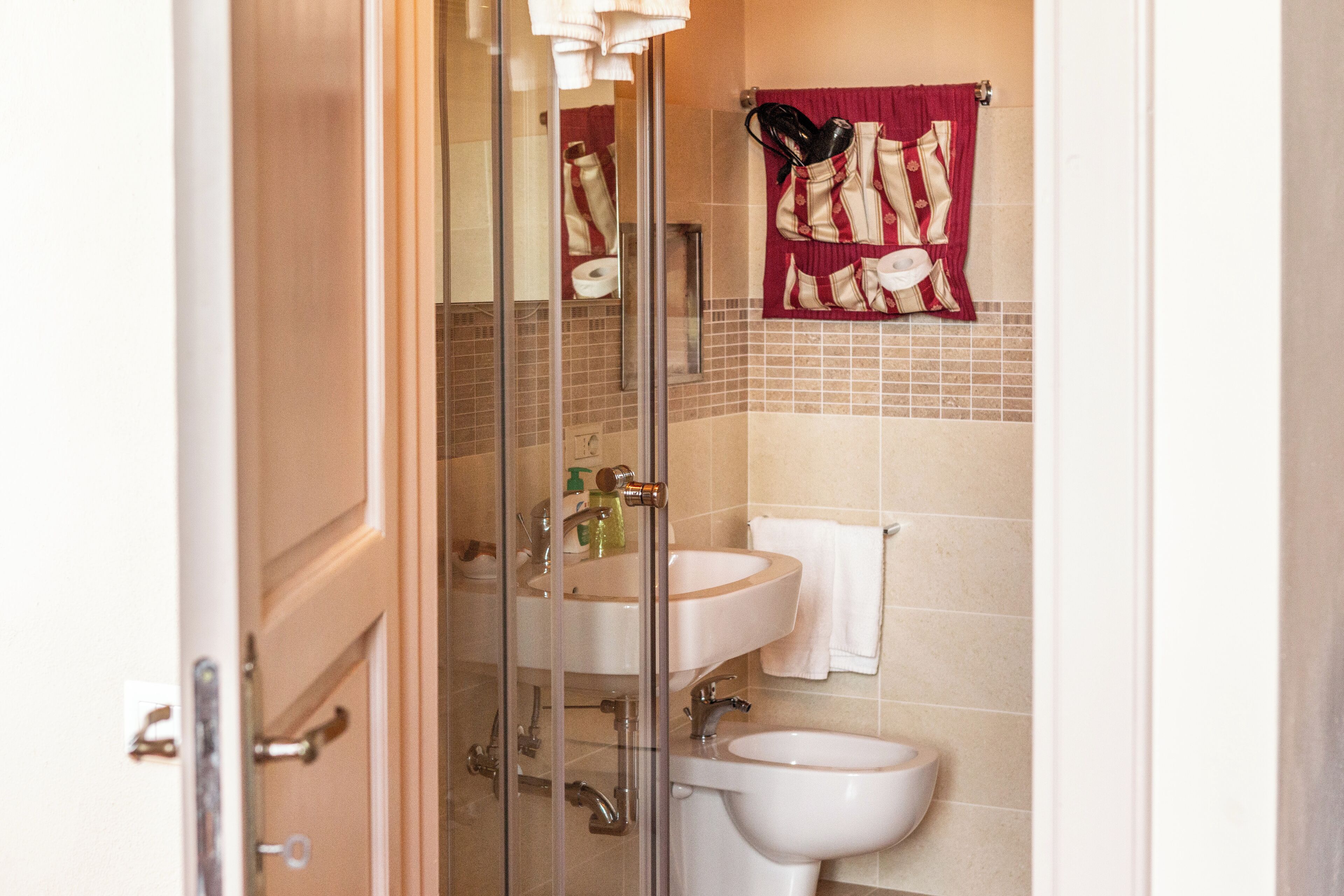 A bathroom with a glass shower enclosure, a sink, and a toilet.