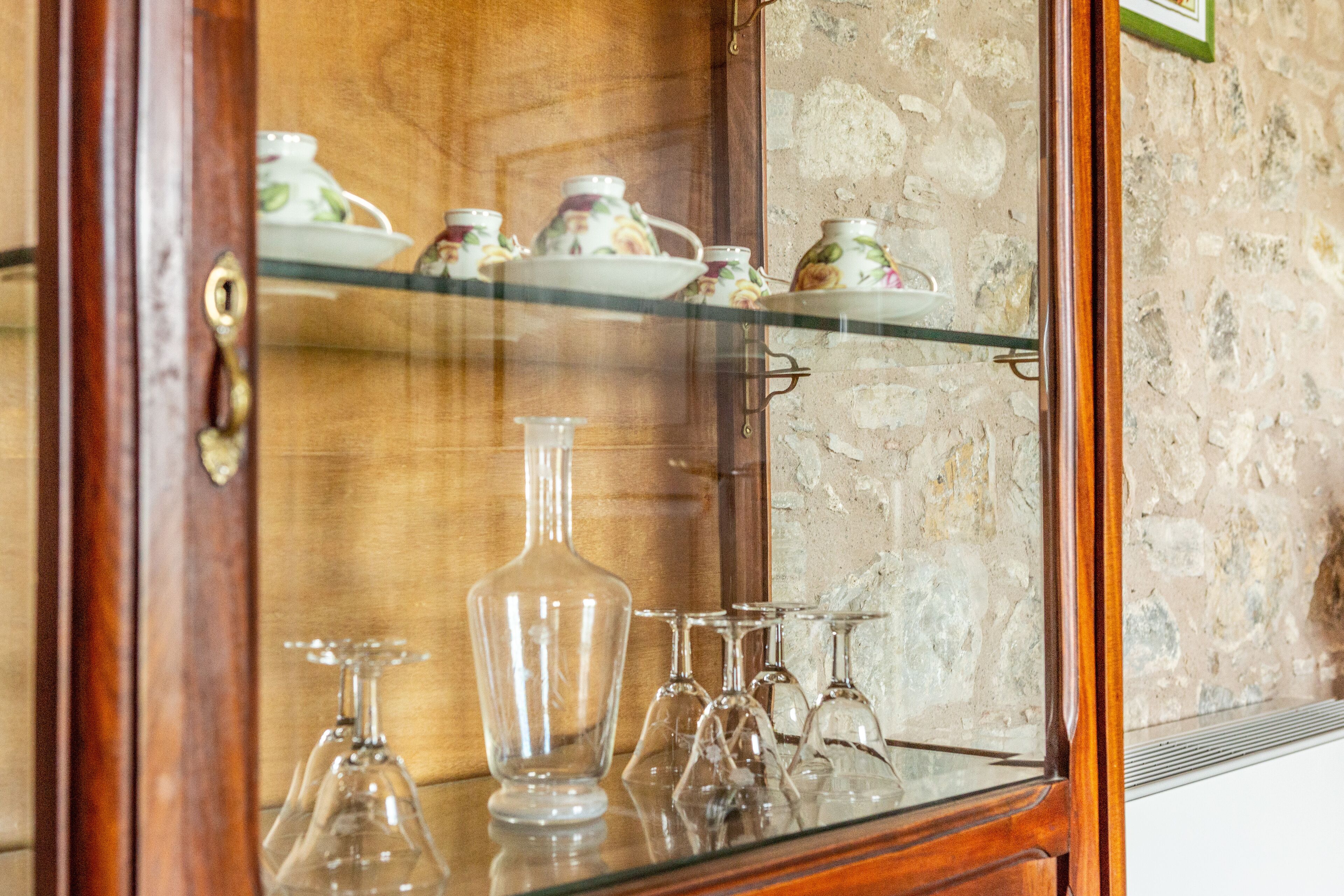A glass display cabinet with tea sets and glassware.