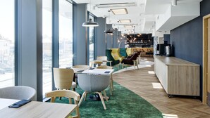 A modern bar area with seating and a bar counter. - B&B HOTEL Tomaszów Lubelski (Tomaszow Lubelski)