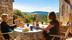 Two people dining at a round table with a view of the mountains. - Domaine de l'Astic  (Vagnas)