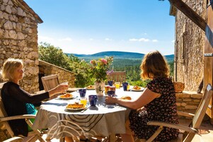 Dos personas cenando en una mesa redonda con vista a las montañas.