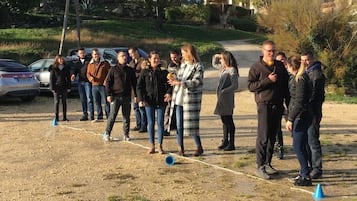 Eine Gruppe von Menschen steht draußen, möglicherweise bei einer gesellschaftlichen Veranstaltung oder einem Treffen.