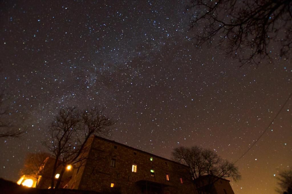 A building with multiple windows against a starry night sky.