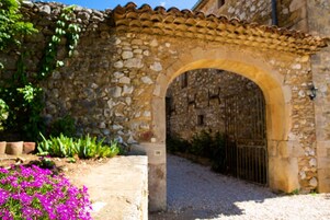 Un arco de piedra que conduce a un edificio con tejado de baldosas.