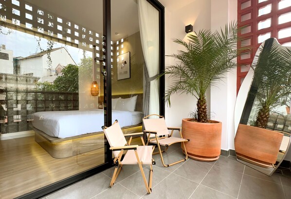 Relax on the balcony with a large bed and comfortable seating area.