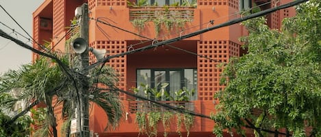 Urban living meets nature at this distinctive building with balconies and lush greenery.
