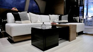 A modern living room with a white sofa, black and white patterned pillows, and a black coffee table with a clear glass top. - El Nido (El Nido)
