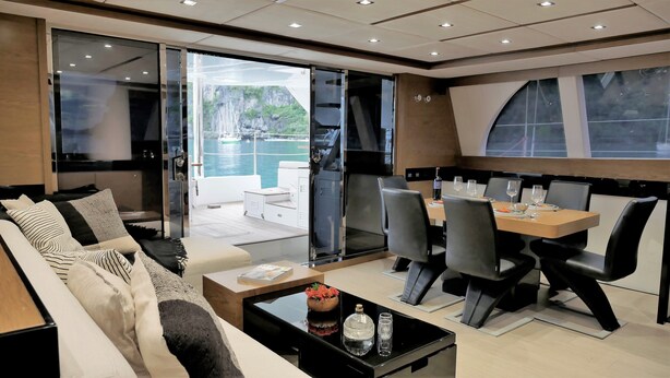 A modern interior with a dining area, a sofa, and a view of the sea. - El Nido (El Nido)