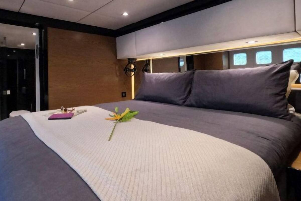 A modern bedroom with a large bed, a bedside table, and a nightstand.