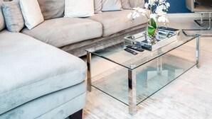 A modern living room with a glass coffee table, a sofa, and two chairs. - HomesGetaway-Torch Marina Dubai Cozy 2BR (Dubai)