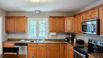 A kitchen with wooden cabinets, a microwave, a stove, and a dishwasher.