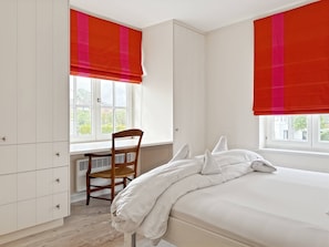 A bedroom with a bed, a chair, a wardrobe, and windows with red blinds. - Luxurious 5-bedroom Holiday House in Knokke-heist Belgique (Knokke-Heist)