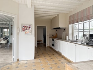 A modern kitchen with white cabinets, a tiled floor, and a coffee machine. - Luxurious 5-bedroom Holiday House in Knokke-heist Belgique (Knokke-Heist)