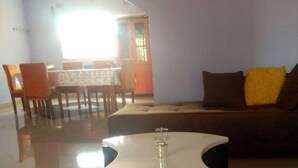 A lobby with a round table, a sofa, and a dining area in the background. - Zambia (Chipata)