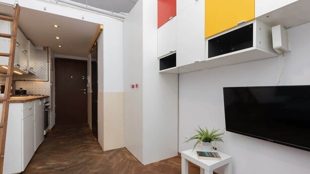 Una cocina moderna con armarios blancos, encimera de madera y estufa integrada.