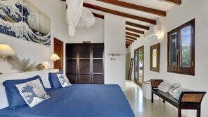 A hotel room with a large bed, a wardrobe, a bench, and a wall with artwork. - Casa de las Brisas with Large Communal Pool (Kralendijk)