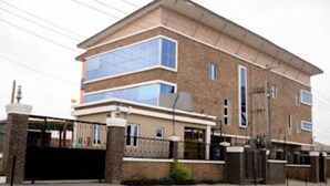 A two-story building with a flat roof, large windows, and a brick facade. - Rivera Hotel and Suites (Ijede)