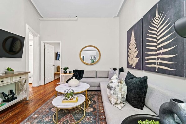 A modern living room with a sofa, coffee table, and artwork on the walls.