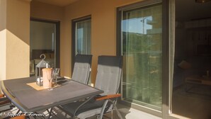 A balcony with a table, chairs, and a lantern. - Apartment Sleeps 4 With Sea View (Rijeka)