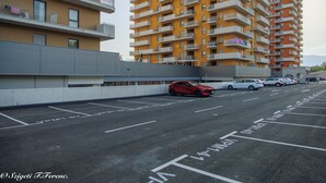 A multi-story parking garage with marked parking spaces and a red car parked in one of the spaces. - Apartment Sleeps 4 With Sea View (Rijeka)