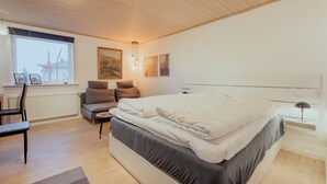 A modern bedroom with a large bed, a desk with a chair, and a window with a star decoration. - Studio Apartment| 20Min From City Center| Tórshavn (Tórshavn)