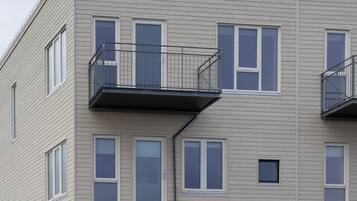 A multi-story building with a flat facade, balconies, and a green door.
