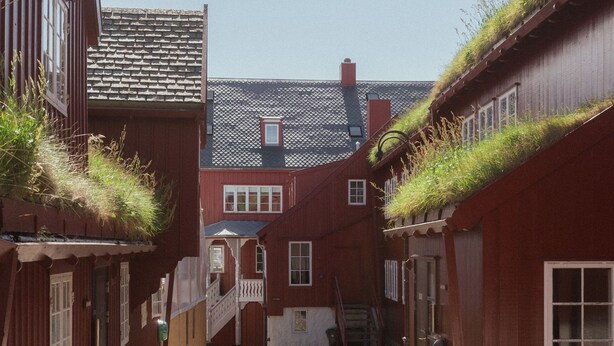 A narrow cobblestone street flanked by traditional wooden buildings with grass-covered roofs. - 1 Bedroom Apartment | Central | Tórshavn (Tórshavn)