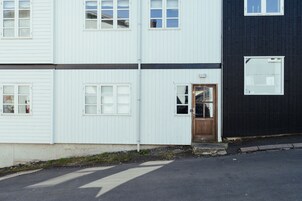 A two-story building with white and black exterior walls, a visible door, and windows.