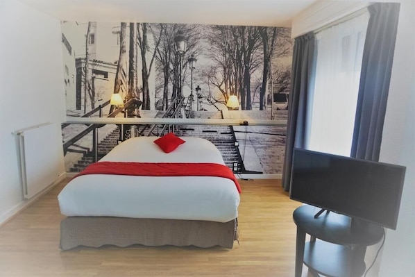 Une chambre à coucher avec un lit, un bureau et un téléviseur.