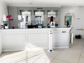 Un área de recepción con mostrador, cartel y ventanilla.