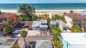 Une zone résidentielle côtière avec des maisons, une plage et un ciel dégagé.