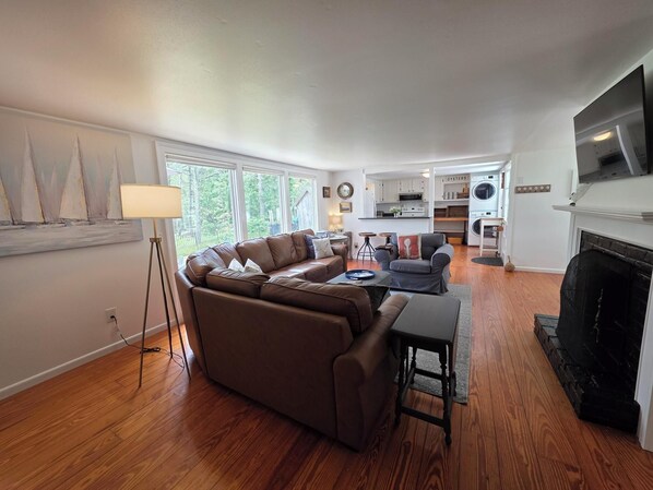 A modern living room with a sectional sofa, a coffee table, and a fireplace.