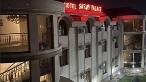 A multi-story hotel with a prominent red sign reading "HOTEL SAROY PALACE". - Saroy Palace Hotel (Qarshi)