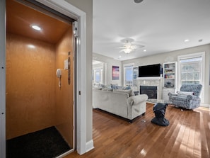 Cozy living room with a fireplace, sofa, coffee table, and armchair, perfect for relaxing.