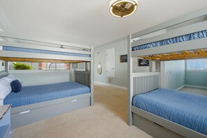 Ein Zimmer mit Etagenbetten, einem Schminktisch, einer Heizung und einem Fenster.