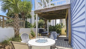 An outdoor patio with a round table, two chairs, a grill, and a covered area. - Private home across from the beach.  4 bed 3.5 bath sleeps 12 (Navarre)