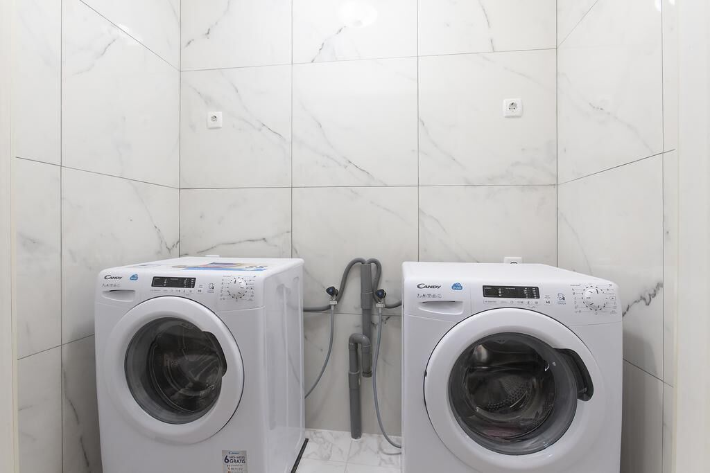 Twee voorladers in een badkamer met witte marmeren tegels.