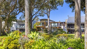 Una zona residencial moderna con casas contemporáneas, jardines exuberantes y árboles maduros.