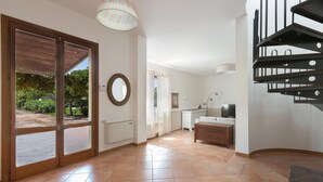 A spacious room with a large sliding glass door leading to an outdoor area, a staircase, and a small kitchenette. - 3600 Al Giardino Dell`eden by Barbarhouse (Lecce)