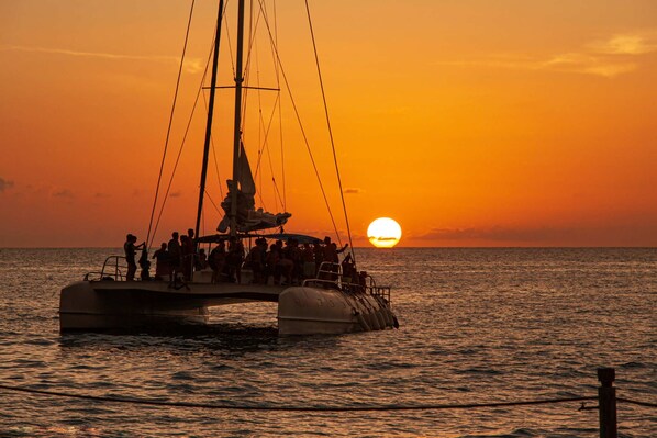 A boat with people on board during sunset.