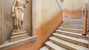 Una escalera de mármol con una estatua de una mujer sosteniendo un cuenco.
