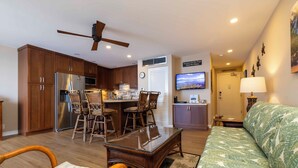 Un espacio habitable compacto con kitchenette, comedor y sofá.
