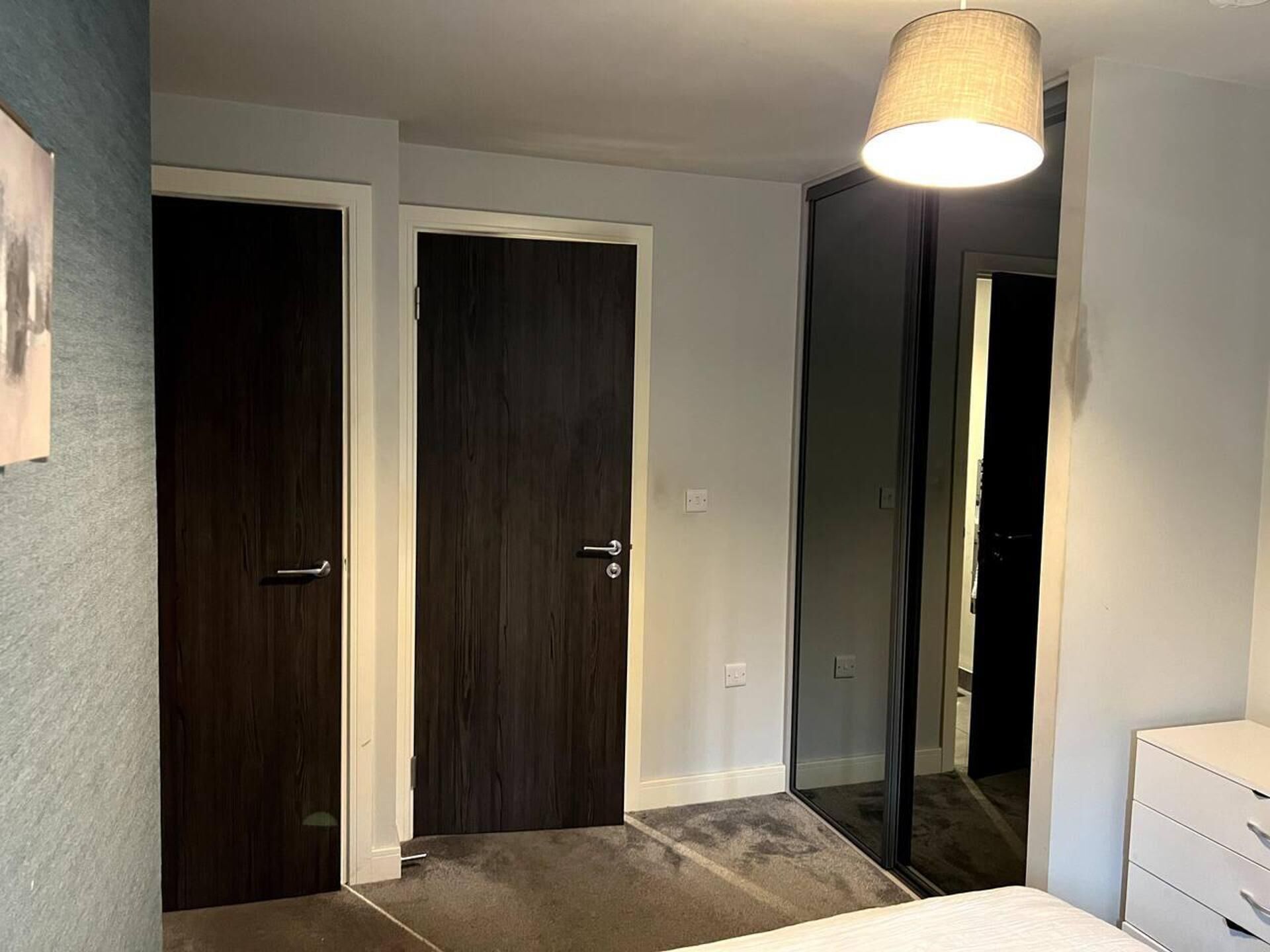 Une chambre à coucher avec un lit, une commode et un miroir.