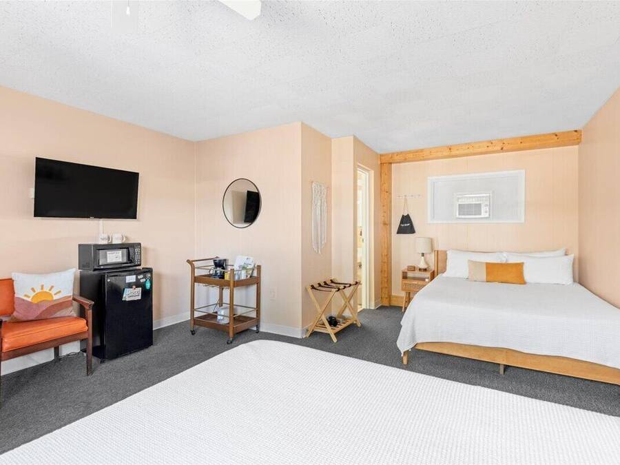 Una camera d'albergo con un letto, una televisione, un forno a microonde, un tavolino e una sedia.