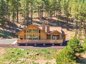 A log cabin with a large deck and multiple windows. - Humphreys Peak View Luxury Log Cabin (Fort Valley)