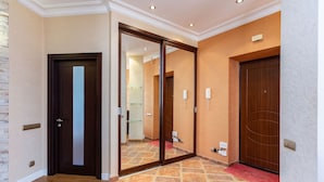 A hotel hallway with a wooden door, a sliding glass door, and a red carpet. - Stylish and new apartments  (Minsk)