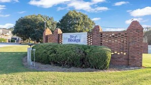 A sign for 'The Brooks' with a brick wall and a well-maintained lawn. - AU Condo Getaway Across From Vet School - Kitchen, Pools, Queen BR, Pets Welcome (Auburn)