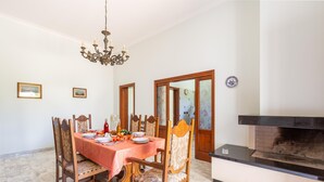A dining room with a marble floor, wooden chairs, a red tablecloth, and a fireplace. - 3611 Casa di Paolo by Barbarhouse (Campi Salentina)